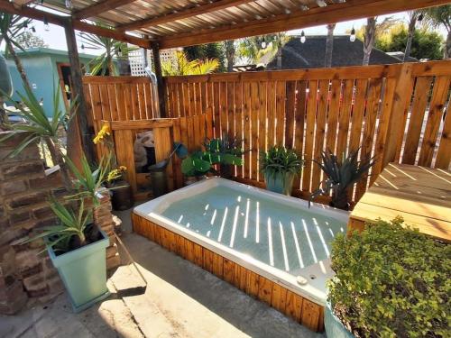 a hot tub in a backyard with a wooden fence at Bosveld In Die Stad Lodge in Alberton