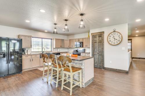 a kitchen with a counter and a clock on the wall at 4 Mi to Dtwn Sturgis Cabin with Hot Tub and Game Room in Crook City