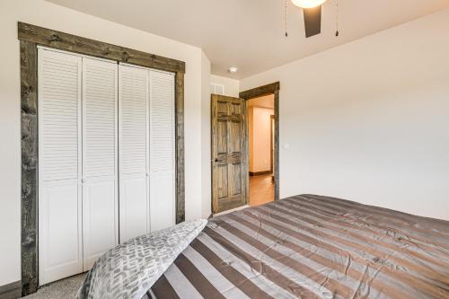 a bedroom with a bed and a sliding barn door at 4 Mi to Dtwn Sturgis Cabin with Hot Tub and Game Room in Crook City