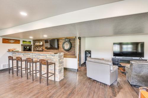 a living room with a bar and a tv at 4 Mi to Dtwn Sturgis Cabin with Hot Tub and Game Room in Crook City