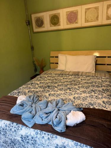 a bedroom with a bed with blue towels on it at Pousada Tiê-Sangue in Iporanga