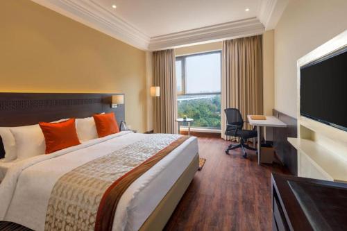 a hotel room with a bed and a flat screen tv at Elite stay 4 in Greater Noida