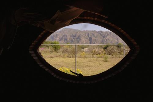 a view of a mountain through a round window at Villas Mexiko in Tepoztlán