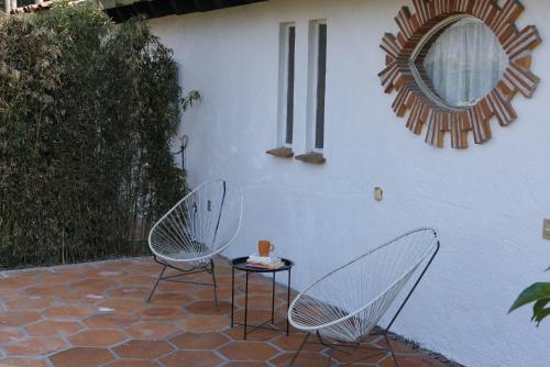 two chairs and a table in front of a building at Villas Mexiko in Tepoztlán