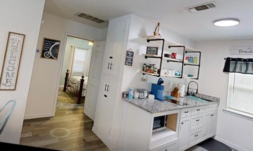 a kitchen with white cabinets and a counter top at Blue Heron cottage in Gulfport