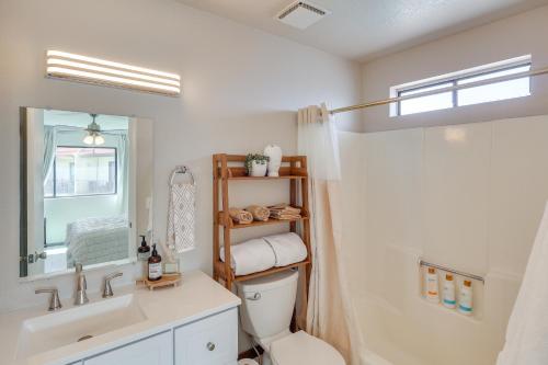 een badkamer met een wastafel, een toilet en een spiegel bij Less Than 2 Mi to London Bridge Chic Condo with Pool Access in Lake Havasu City