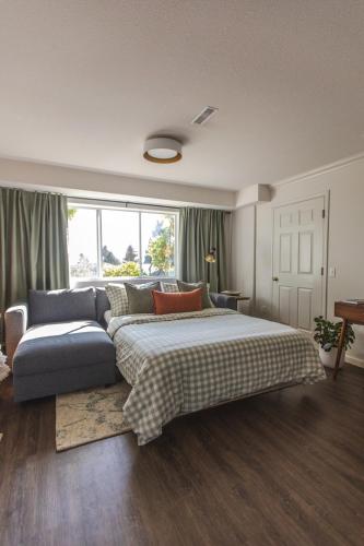 a bedroom with a large bed and a couch at Modern Lynn Valley Retreat with Mountain and City Views in North Vancouver