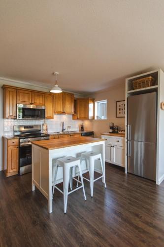 a kitchen with a white table and a refrigerator at Modern Lynn Valley Retreat with Mountain and City Views in North Vancouver