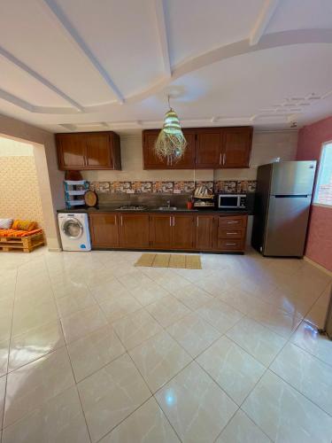 a large kitchen with wooden cabinets and a refrigerator at Papaya Hostel in Agadir