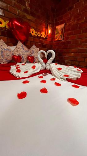 a bed with red hearts on top of it at Pousada Dona Felicidade Carneiros in Tamandaré