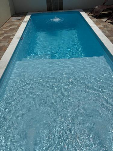 a pool of blue water with chairs in it at Pousada Peromar in Maragogi