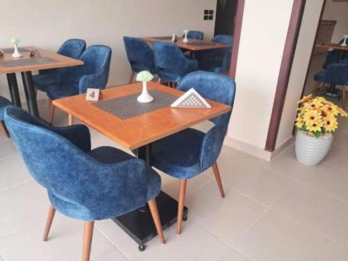 a dining room with blue chairs and a wooden table at Merna pyramids View hotel in Cairo