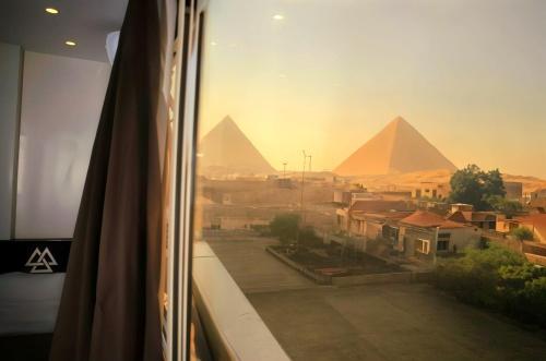 a view of the pyramids from a window of a room at Merna pyramids View hotel in Cairo