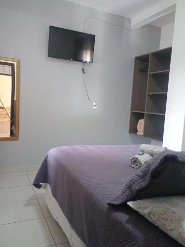 a bedroom with a bed and a lamp on the wall at Residencial Caramujo in Florianópolis