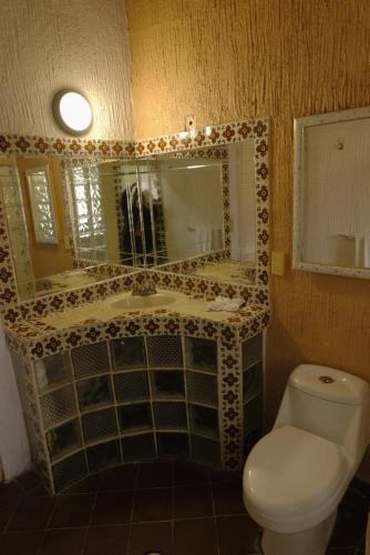 a bathroom with a toilet and a sink and a mirror at Villas Mexiko in Tepoztlán
