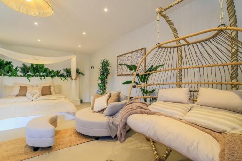 a bedroom with two beds and a swing at Bali Lodge - Evasion balinaise - Jaccuzzi - Sauna in Lens