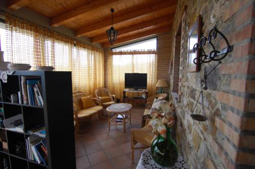 Una sala de estar con un sofá y un televisor. en Agriturismo Tempa del Niglio, en Ascea