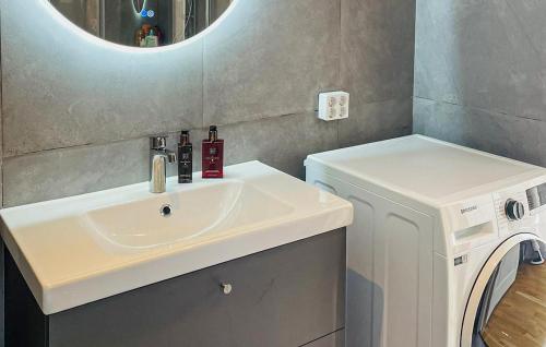 a bathroom with a sink and a washing machine at Awesome Home In Ingarö With Ethernet Internet in Forsvik