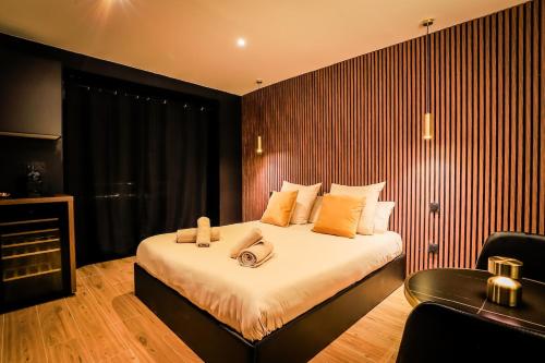 a hotel room with a large bed and a chair at Golden Suite - Elegance - Private Spa Jacuzzi in Lens