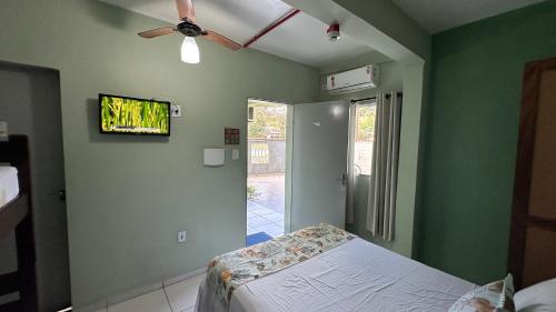 a bedroom with a bed and a flat screen tv at Pousada Suíte Verde Mar in Ubatuba