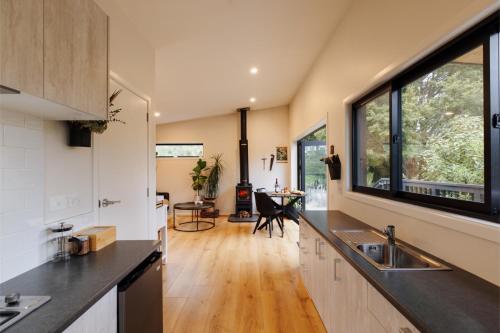 a kitchen with a sink and a large window at Hidden Springs Retreat - Karangahake Mountain View in Karangahake