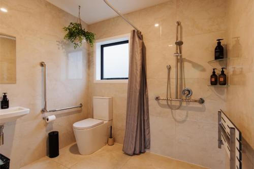 a bathroom with a toilet and a shower at Hidden Springs Retreat - Karangahake Mountain View in Karangahake