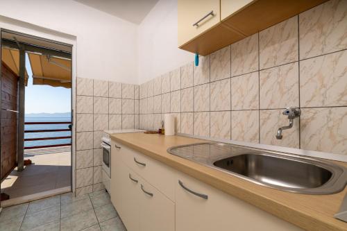 a kitchen with a sink and a view of the ocean at Seaside secluded apartments Cove Torac, Hvar - 589 in Gdinj