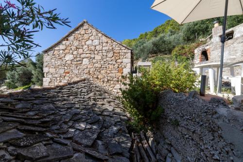 an umbrella sitting on top of a stone house at Seaside secluded apartments Cove Torac, Hvar - 589 in Gdinj