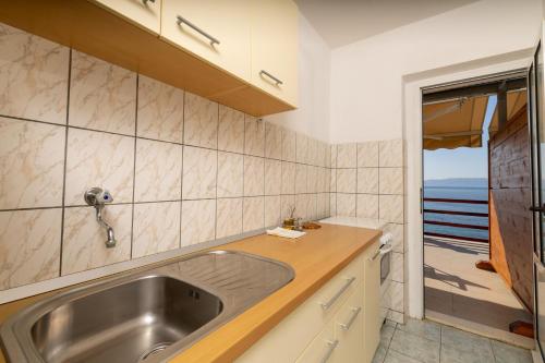 a kitchen with a sink and a view of the ocean at Seaside secluded apartments Cove Torac, Hvar - 589 in Gdinj