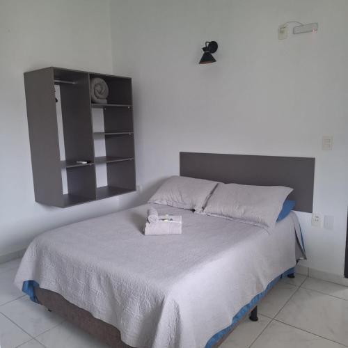 a bedroom with a bed with a mirror on the wall at Residencial Caramujo in Florianópolis