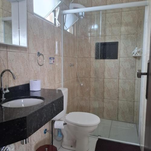 a bathroom with a toilet and a sink and a shower at Residencial Caramujo in Florianópolis