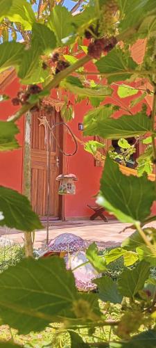 a red building with an umbrella in front of it at Chalé Refúgio dos Gnomos in Visconde De Maua