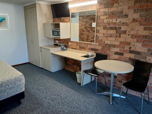 a small kitchen with a desk and a table in a room at Cardiff Motor Inn in Cardiff