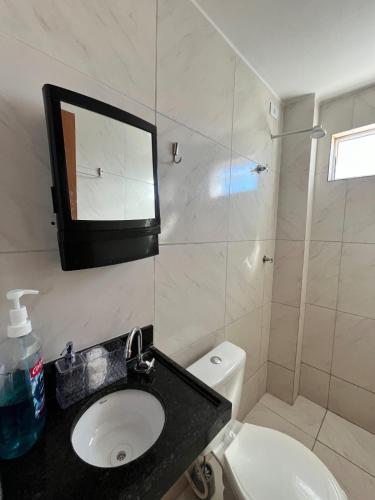 a bathroom with a sink and a toilet and a mirror at Apartamento Jampa in João Pessoa