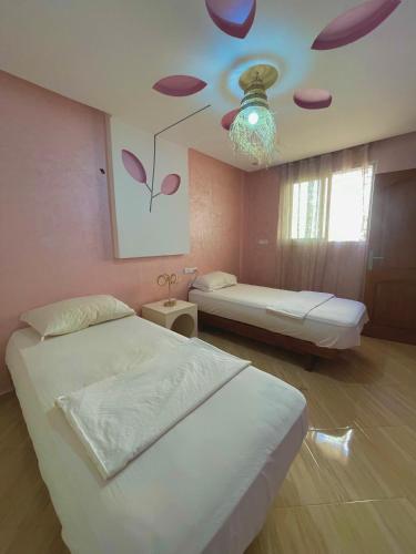 a bedroom with two beds and a ceiling with purple onions at Papaya Hostel in Agadir