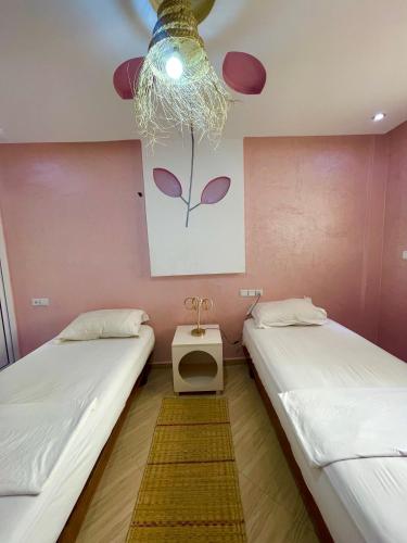 two beds in a room with a painting on the wall at Papaya Hostel in Agadir