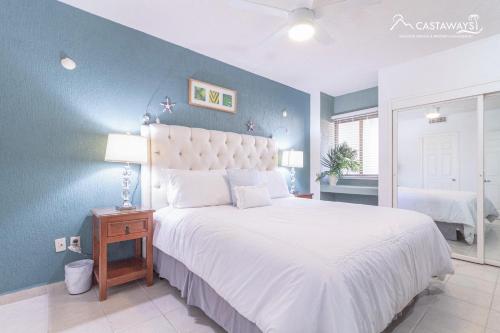 una camera da letto con un grande letto bianco e una parete blu di Sonoran Spa N502 a Campo del Medio