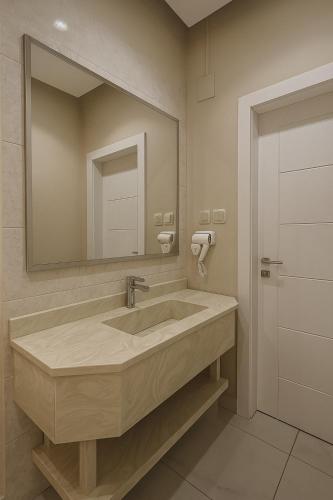 a bathroom with a large sink and a mirror at أجنحة هدوء وصول ذاتي in Medina
