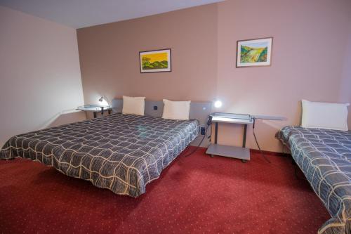 a hotel room with two beds and a desk at ATM Hotel in Sofia