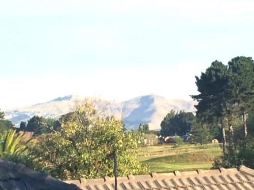 a view of a field with mountains in the background at Spacious City Apartment With Amazing Views in Christchurch