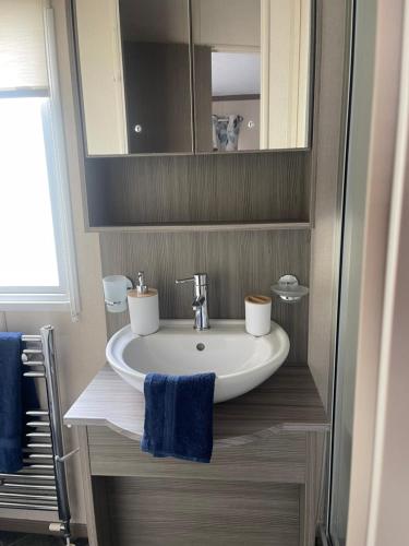 a bathroom with a sink and a mirror at Spacious Modern Seaside Caravan in Lossiemouth