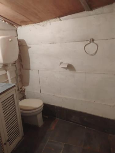 a bathroom with a toilet and a toilet paper holder at Cabaña in Punta Del Diablo
