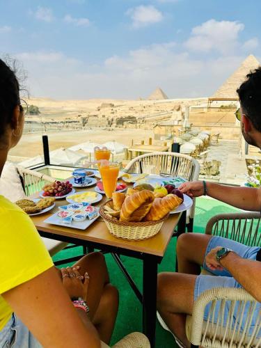 a group of people sitting around a table with food at Inside Pyramids Inn in Banī Ghālib