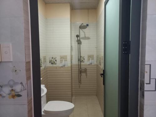 a bathroom with a shower and a toilet at Khách Sạn Nguyên Trung in Ho Chi Minh City