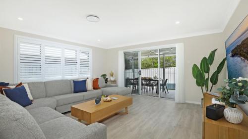 a living room with a couch and a table at Coastal Drift in Callala Bay