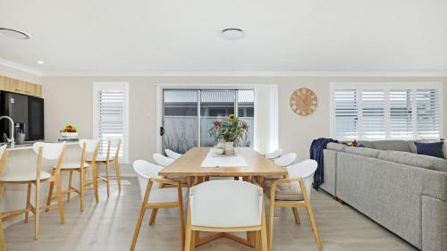 a dining room and kitchen with a table and chairs at Coastal Drift in Callala Bay