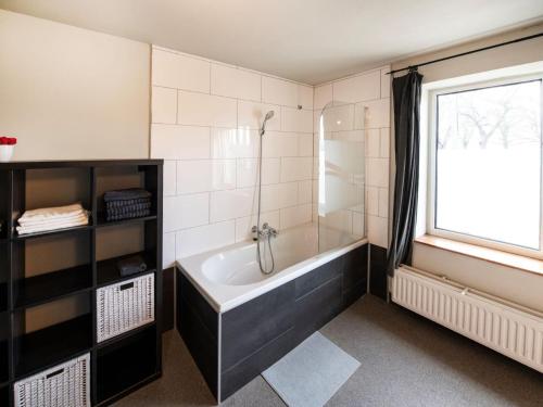 une salle de bain avec une baignoire et une fenêtre dans l'établissement Single-storey holiday home in Heers, à Heers
