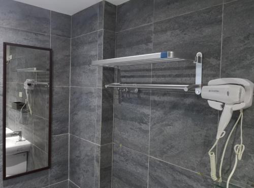 a shower with a hair dryer and a mirror in a bathroom at Casita Angela in Panglao