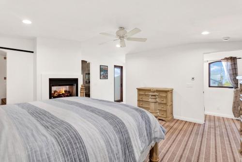 a white bedroom with a bed and a fireplace at Silverstrand Beach House in Oxnard