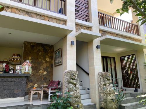 a building with a table and chairs in front of it at ThreeWin Homestay in Ubud